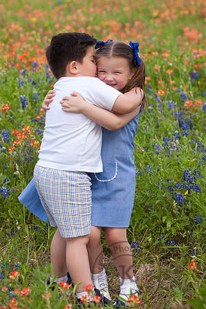 Portrait of Brother and Sister Hugging in Wildflowers