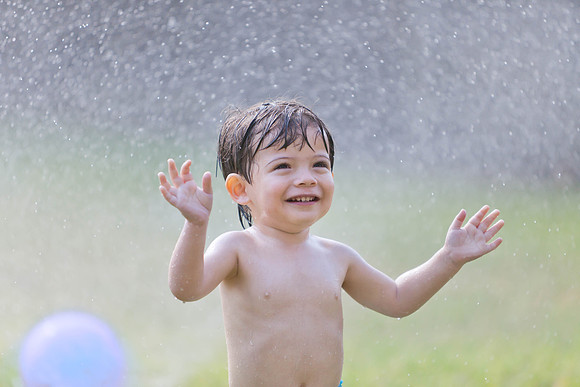 Portrait of Toddler Playing in Sprinklers