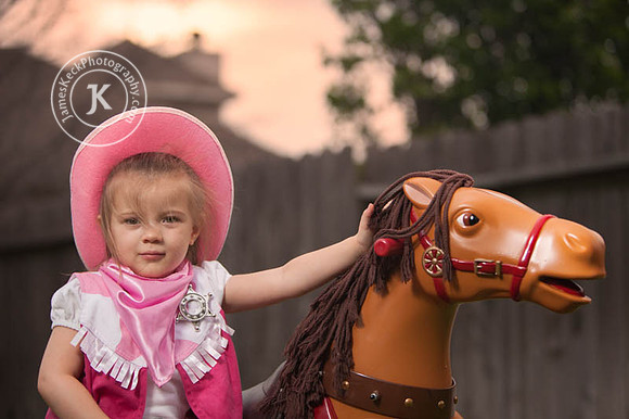 Girl Dressed as Cowgirl Standing Next to Toy Horse