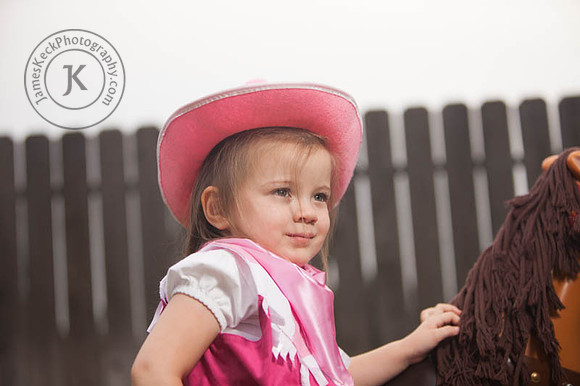 Portrait of Girl Dressed as a Cowgirl Next to a Toy Horse