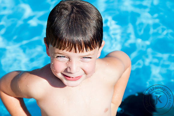 Boy Smiling Next to Pool