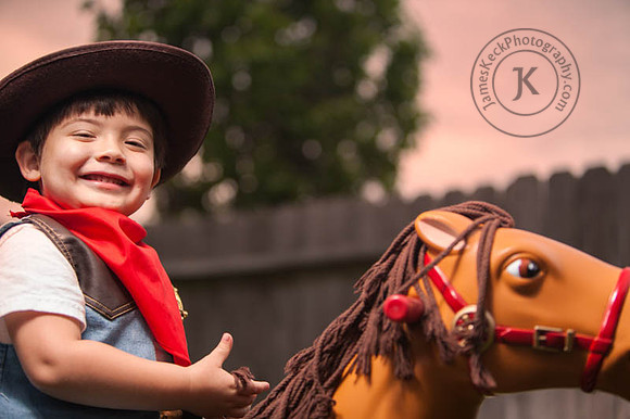 Boy Dressed as Cowboy Riding Toy Horse