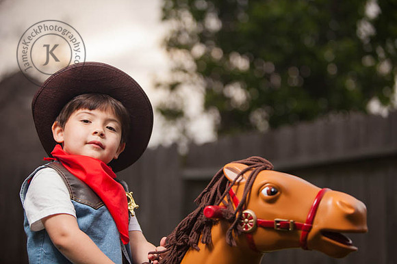 Portrait of Boy Dressed as a Cowboy Riding a Toy Horse