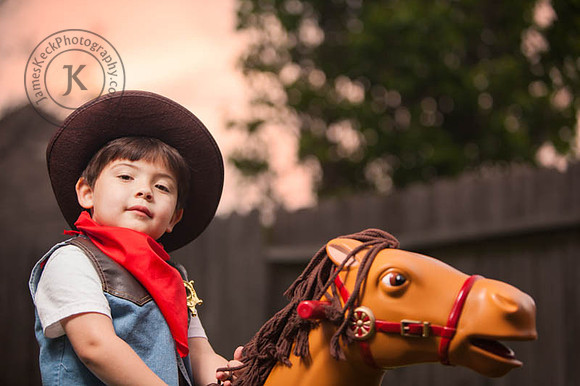 Boy Dressed as Cowboy Riding Toy Horse