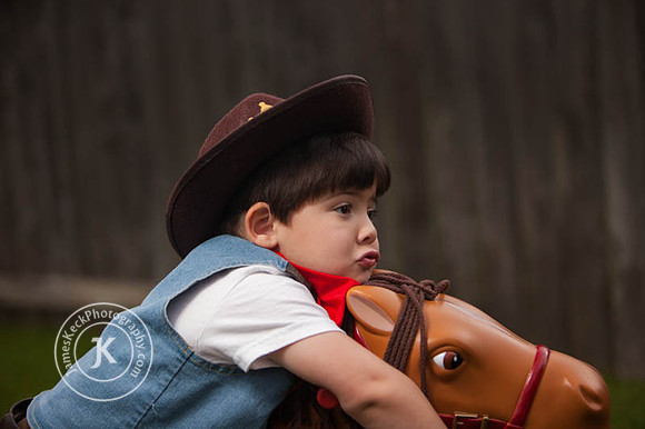 Boy Dressed as a Cowboy Slouched Over a Toy Horse