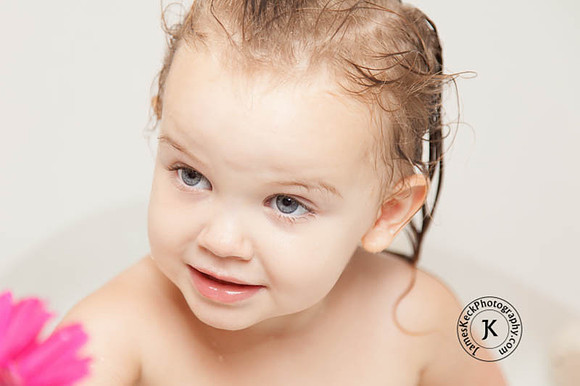 Portrait of Little Girl with Gerbera Daisies in Bathtub