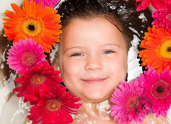 Portrait of Smiling Girl with Gerbera Daisies in Bathtub