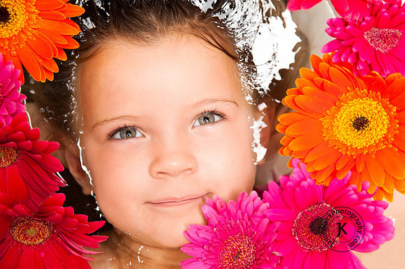 Portrait of Girl with Gerbera Daisies in Bathtub Looking Up