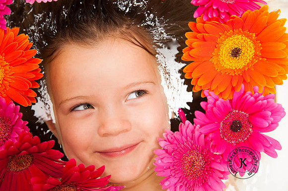 Portrait of Girl with Gerbera Daisies in Bathtub Looking to the Side