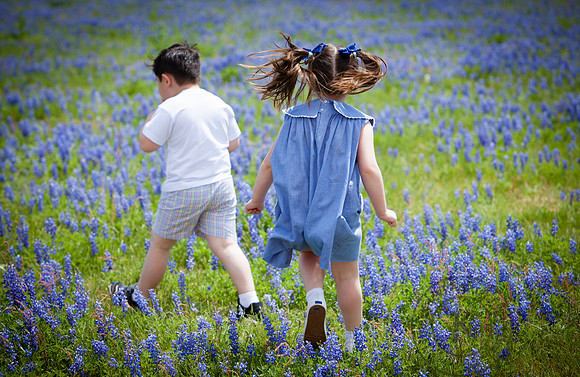 Portrait of Children Running Through Bluebonnets