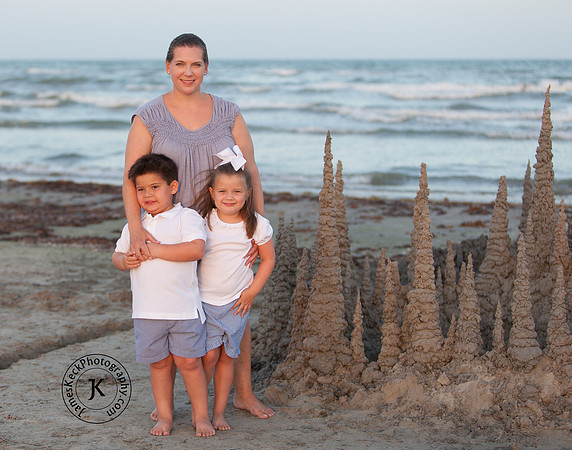 Mother, Son, and Daughter Portrait on the Beach with Sand Castle