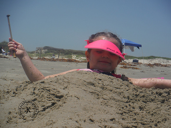 Little Girl Covered in Sand on the Beach