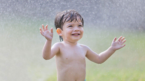 Toddler Playing in Sprinkler