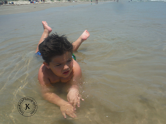 Boy Laying Down in the Sand on the Beach