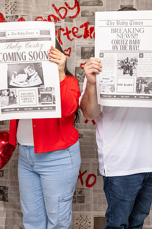 Couple Holding Baby Announcement Newspaper in front of Face