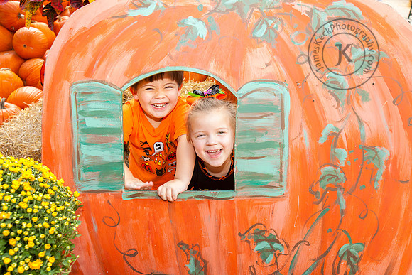 Smiling Boy and Girl Inside Pumpkin